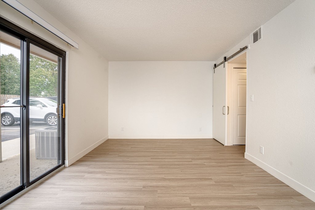 a bedroom with a sliding glass door and hardwood floors